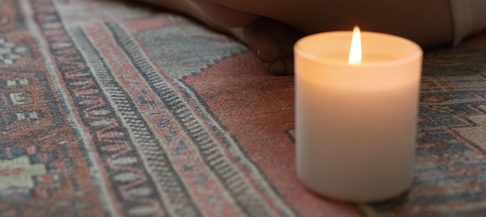 Woman Meditating Next to a Burning Candle